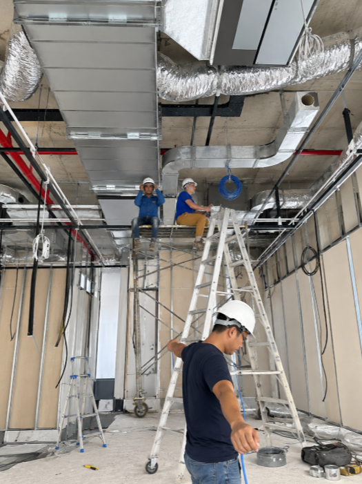 Workers installing ceiling services in a commercial office